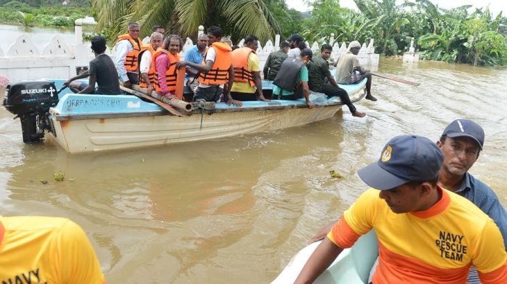 Sri Lankan villagers are evacuated through floodwaters in Nagoda in Kalutara district