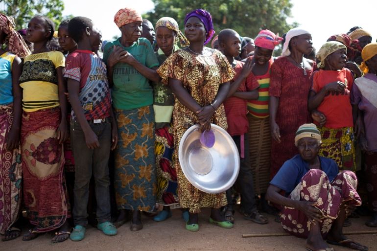Women stand in line for food aid distribution in the village of Makunzi Wali