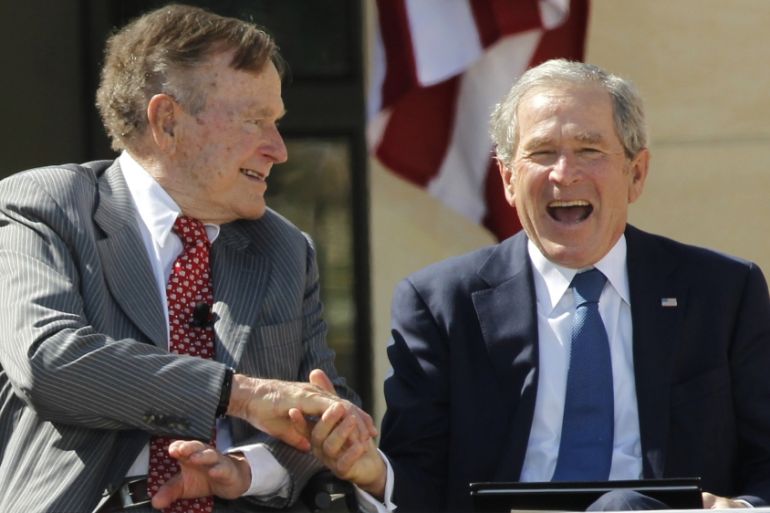Former U.S. Presidents George H.W. Bush and George W. Bush shake hands at the dedication for the George W. Bush Presidential Center in Texas