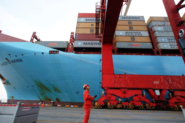 A worker is seen next to the Maersk''s Triple-E giant container ship Maersk Majestic at the Yangshan Deep Water Port in Shanghai
