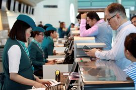 Staff speak with passengers at Hamad International Airport in Doha
