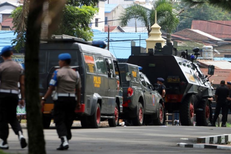 Police are seen near the scene of an attack on a post that left one officer dead in Medan