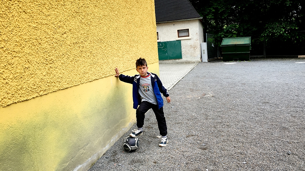 A young asylum seeker plays outside the school in Clausnitz [Jacob Kushner/Al Jazeera]