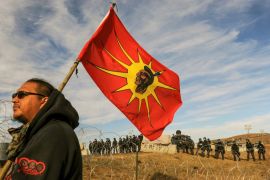 A protesters flies a flag during a stand off with police during a protest of the Dakota Access pipeline near the Standing Rock Indian Reservation near Cannon Ball, North Dakota