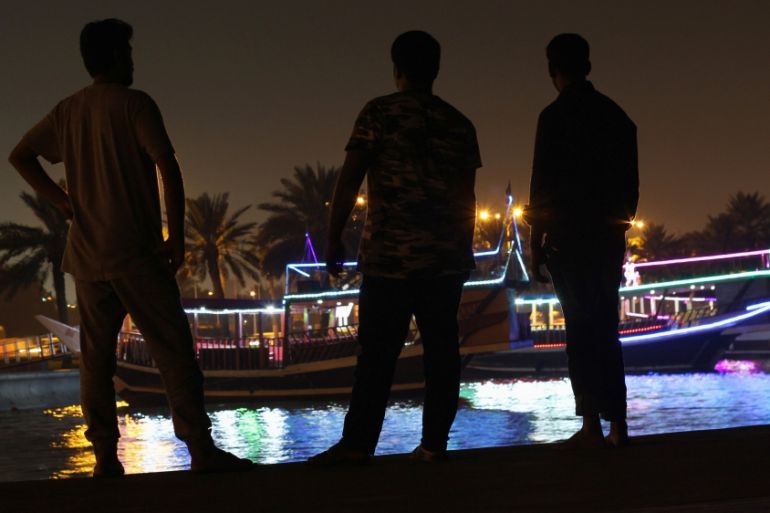 People stand on the corniche in Doha