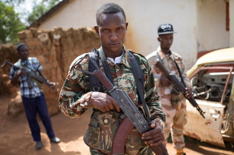 Armed fighters belonging to the 3R armed militia stands guard while their leader General Sadiki is talking to the media in the town of Koui, Central African Republic