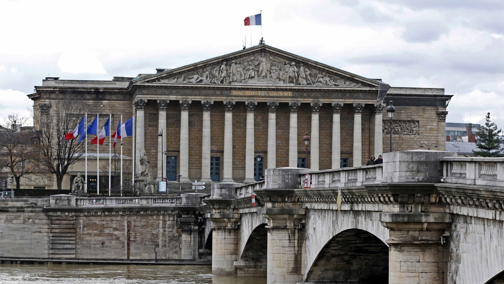 The French flag flies atop the National Assembly building in Paris where French deputies debate and vote on laws [File: Charles Platiau/Reuters]
