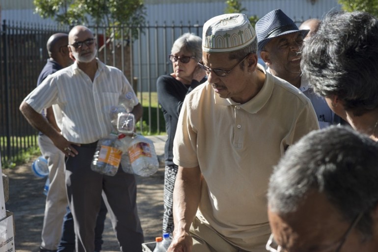 People queue up to collect drinking water in Newlands