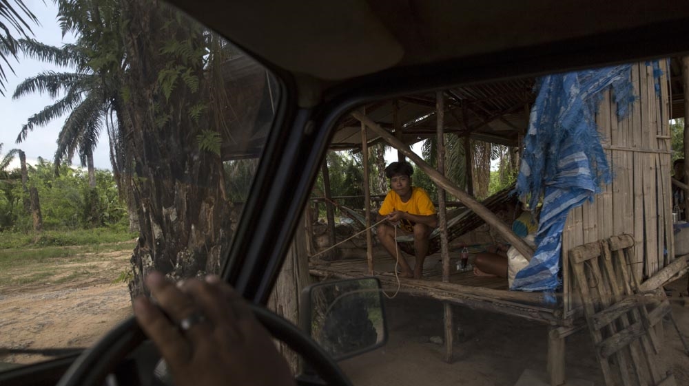 A pick-up truck leaves the village as the security guard opens the guard post. All vehicles entering the village are documented in books noting the licence plate and time of entry and is used as evidence if something happens [Luke Duggleby/Al Jazeera]