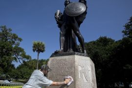 Mullins cleans graffiti off the pedestal of a bronze statue to the "Confederate defenders of Charleston" in Charleston