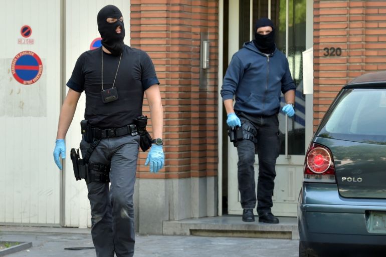 Belgian policeman get out of a house after searching it in Brussels
