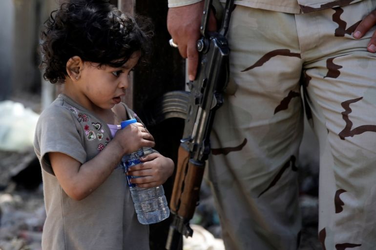 A displaced girl holds a bottle of water after her family fled their home due to fighting between Iraqi forces and Islamic State militants, near the Old City in western Mosul