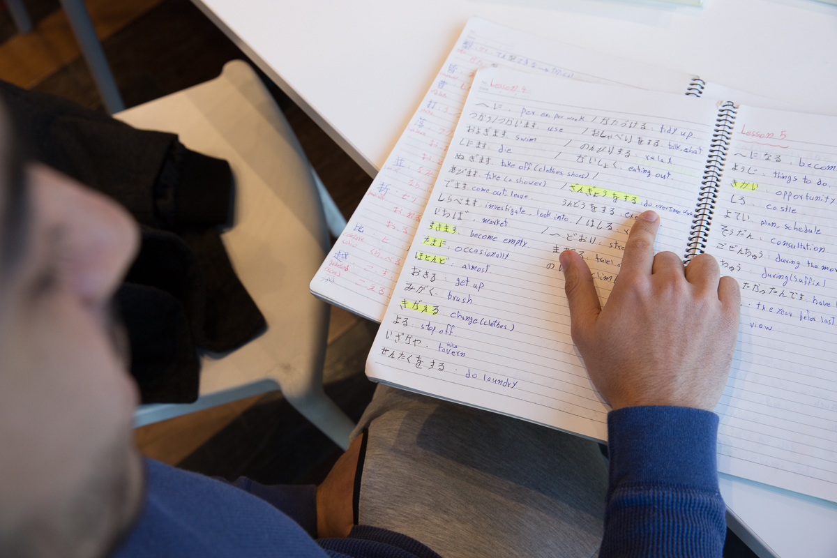Jamal displays some of his Japanese language workbooks [Shiori Ito/Al Jazeera]