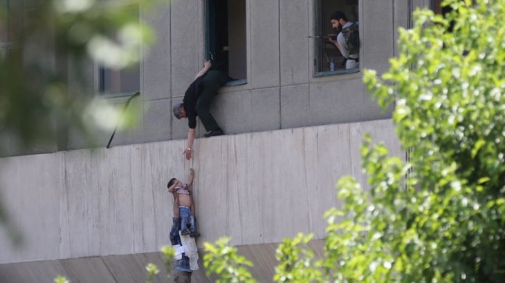 Boy is evacuated during an attack on the Iranian parliament in central Tehran