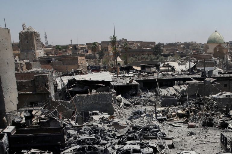A destroyed al-Hadba minaret at Grand al-Nuri Mosque (L) is seen with the ruins of the mosque and other destroyed houses from the Iraqi forces positions at the Old City in Mosul