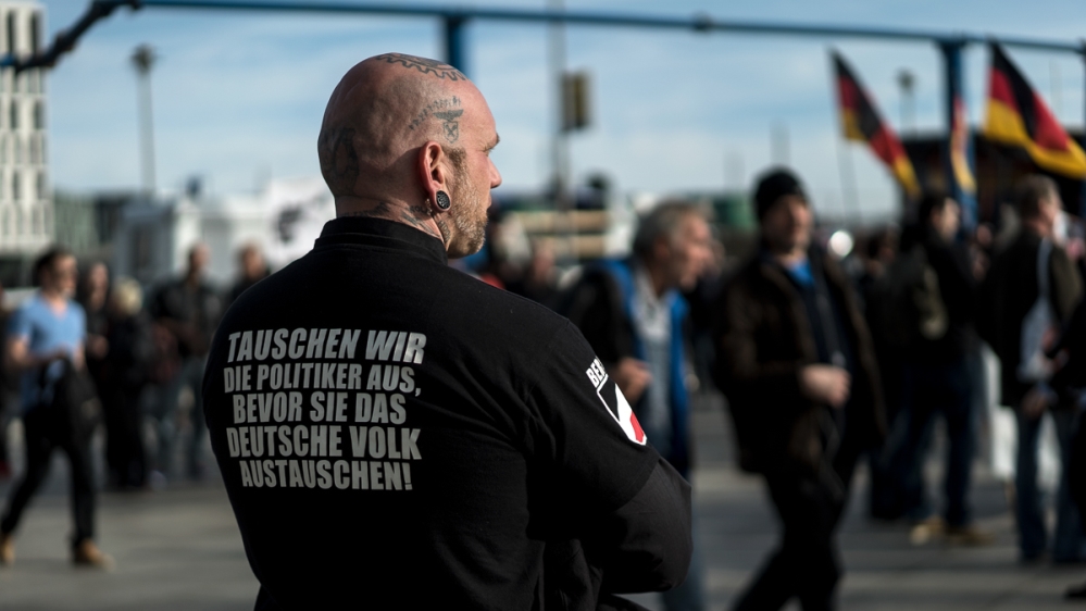 A far-right demonstrator's shirt reads: 'Let's change the politicians before they change the German people.' [Sorin Furcoi/Al Jazeera]