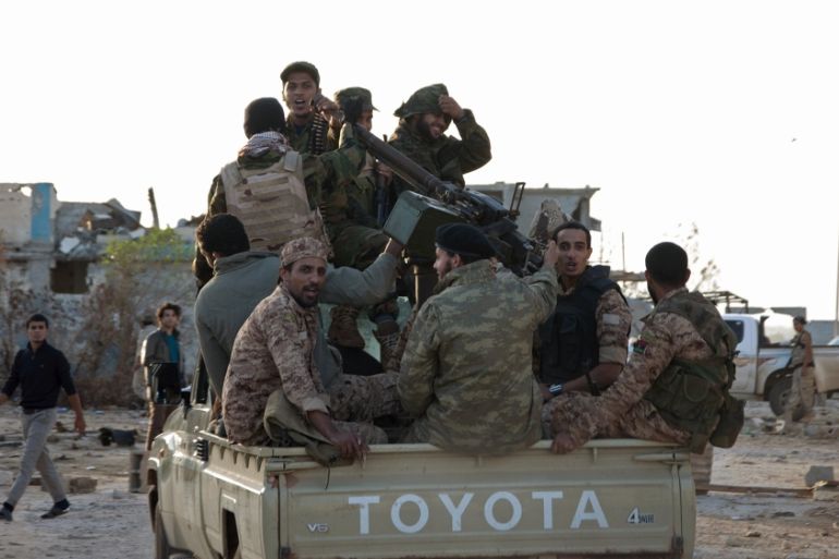 Members of forces loyal to former general Khalifa Haftar ride in a truck in the Benina area, east of Benghazi