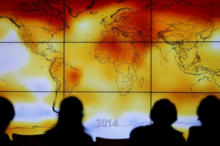 FILE PHOTO: Participants looks at a screen projecting a world map with climate anomalies during the World Climate Change Conference 2015 (COP21) at Le Bourget