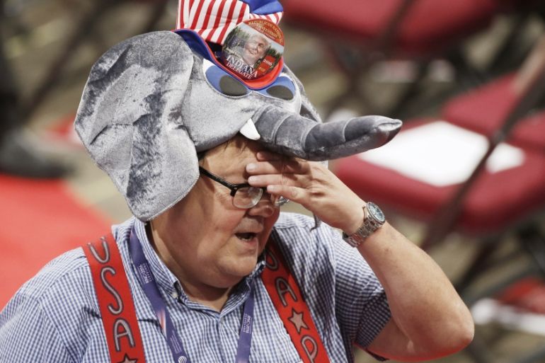 A delegate with a GOP mascot elephant wipes his brow on the floor at the Republican National Convention in Cleveland