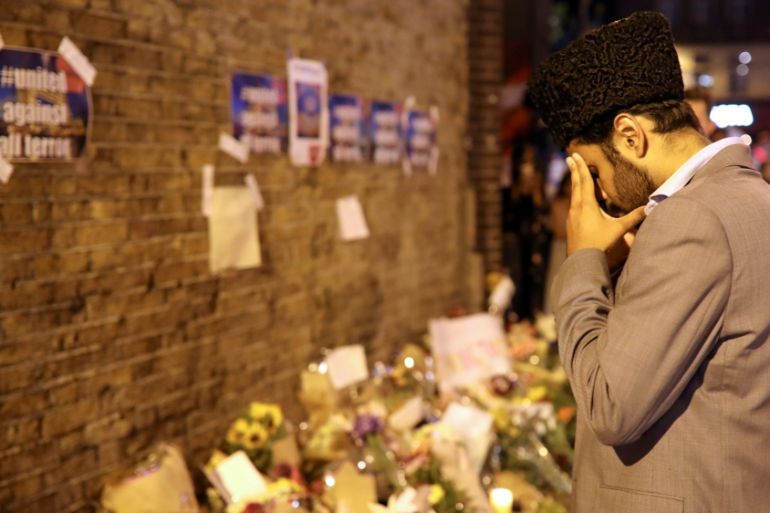 A man prays in front of messages and tributes left near to where a van was driven at muslims in Finsbury Park, North London