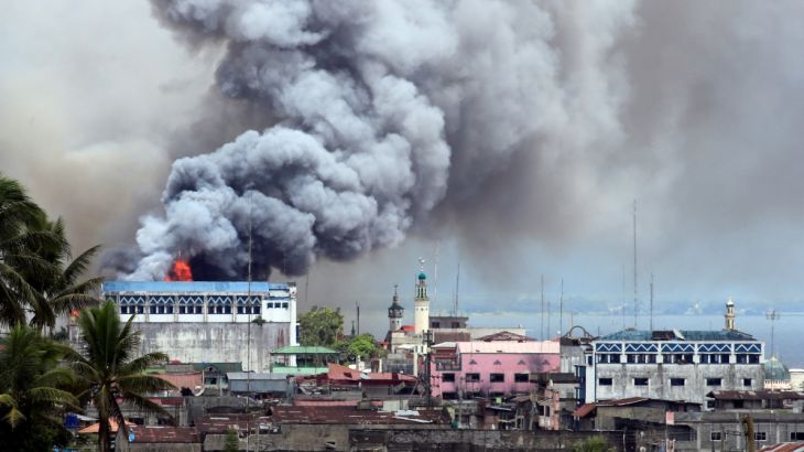 Black smoke comes from a burning building in a commercial area of Osmena street in Marawi city