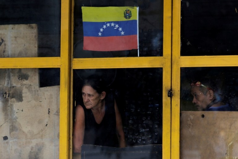 A couple look through a window during a strike called to protest against Venezuelan President Nicolas Maduro''s government in Caracas