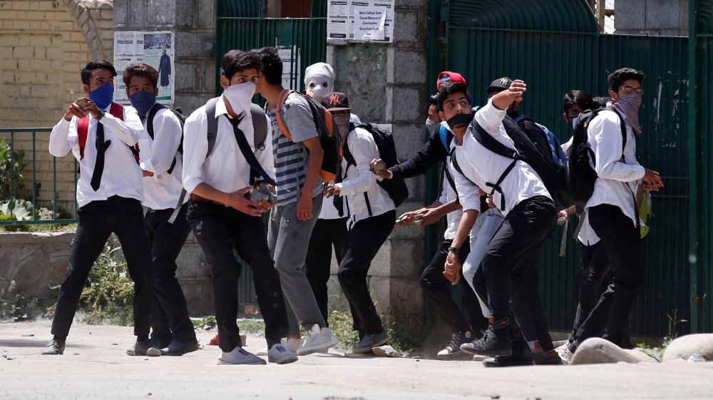 Masked students hurl stones at Indian policemen during a protest outside a college in Srinagar on May 23, 2017 [Reuters/Danish Ismail]