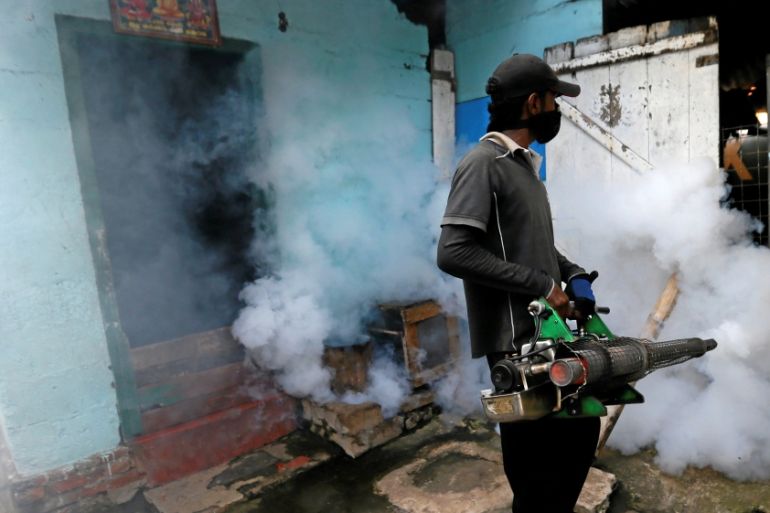 A health worker fumigates an area in an effort to curb dengue in a neighbourhood in Colombo