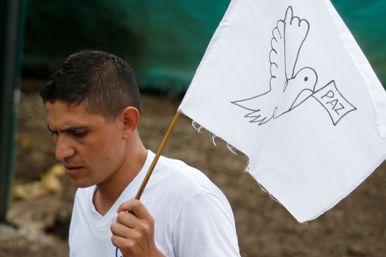 A FARC rebel waves a peace flag during the final act of abandonment of arms in Mesetas