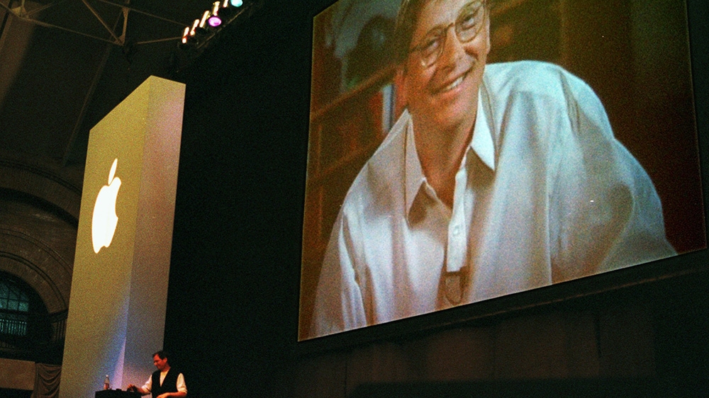 Gates appears on video screen at the 1997 Macworld Expo where Steve Jobs announced that Apple would be entering into partnership with Microsoft [AP]