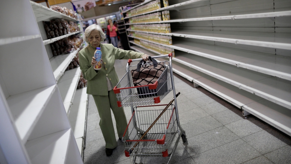 People buy food and other staple goods inside a supermarket in Caracas on July 25, 201 [Ueslei Marcelino/Reuters]
