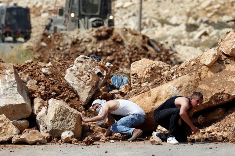 Palestinians take cover during clashes with Israeli troops in the West Bank village of Khobar near Ramallah