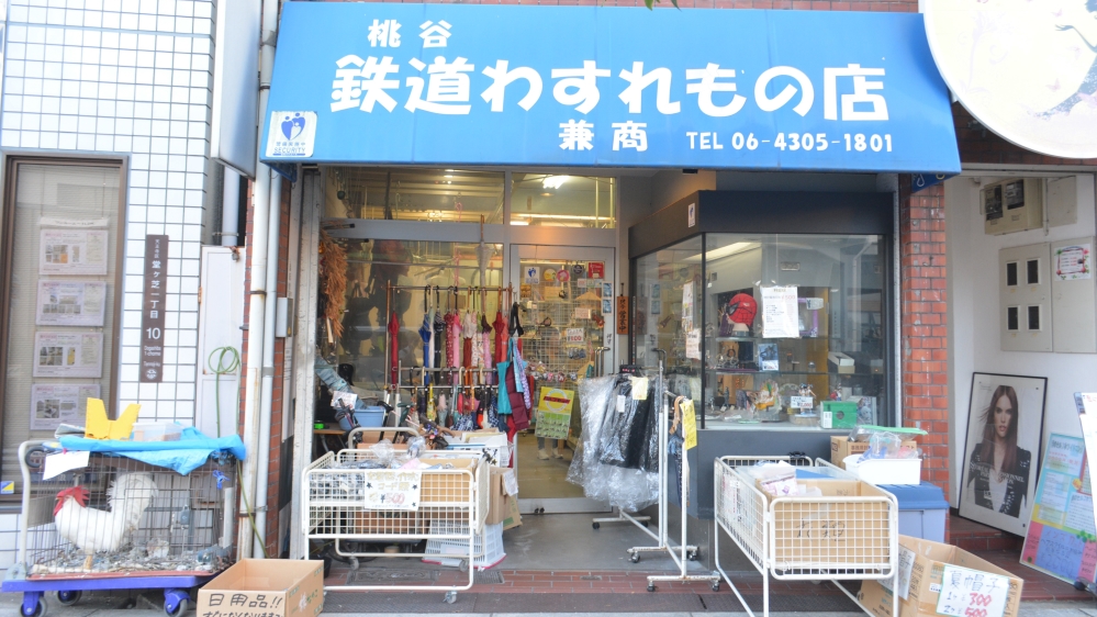 The cockerel that Takahashi found five years ago sits outside his shop [JJ O'Donoghue/Al Jazeera]