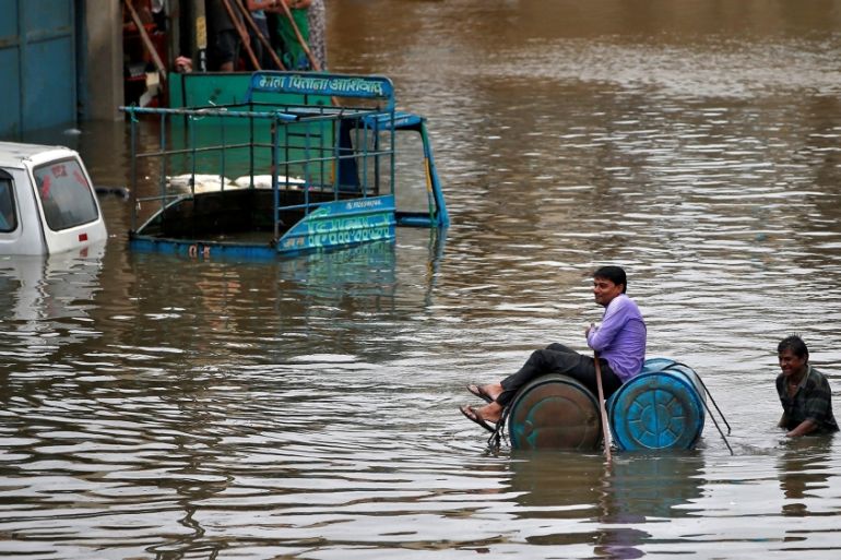 A man uses a makeshift raft to move out of a flooded neighbourhood after heavy rains in Ahmedabad