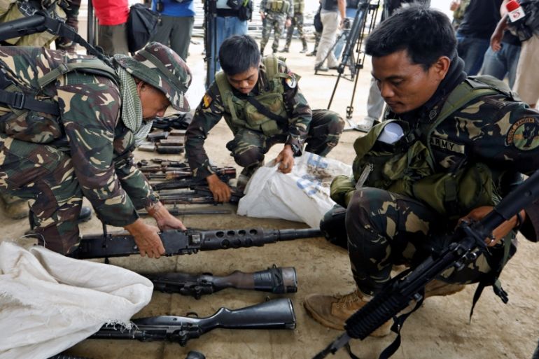 Philippines army soldiers store seized combat weapons in bags after a news conference, as government troops continue their assault against insurgents from the Maute group in Marawi city