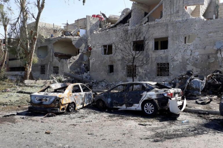 Damaged cars are seen at one of the blast sites in Damascus