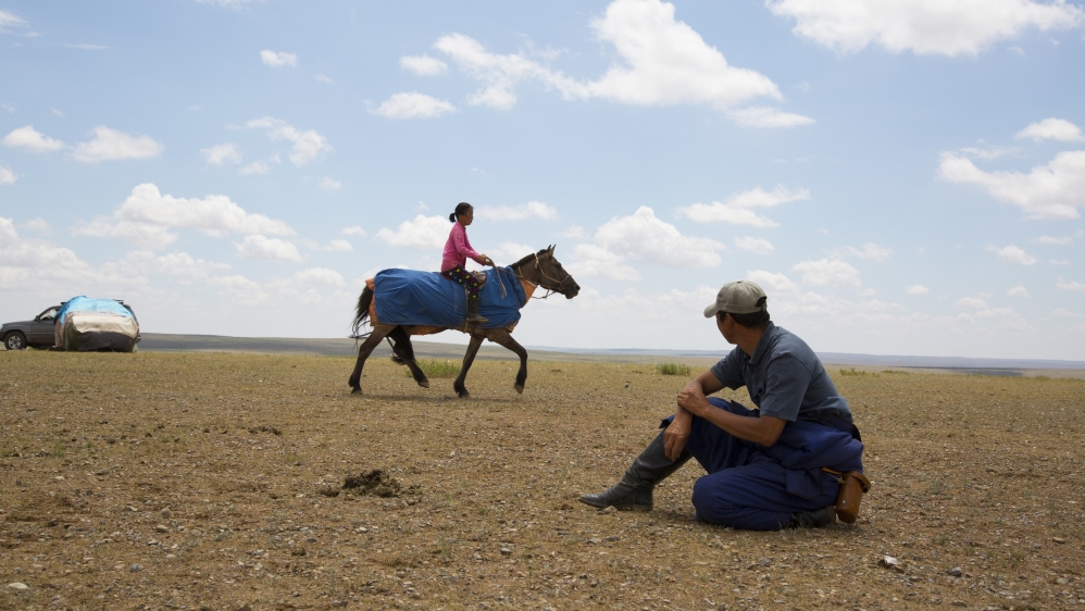 Bujinlkham Damdinsuren’s father watches the nine-year-old as she begins her last training ride before she competes in a 24km horse race as part of Mongolia’s countrywide Naadam festival. Bujinlkham will be one of just three girls competing, and her family hopes she comes in the top five of 50 competitors [Hannah Griffin/Al Jazeera]
