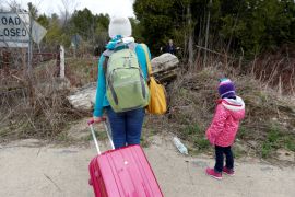 A mother and child approach the Canadian border near Roxham Road in 2017 [File: Christinne Muschi/Reuters]