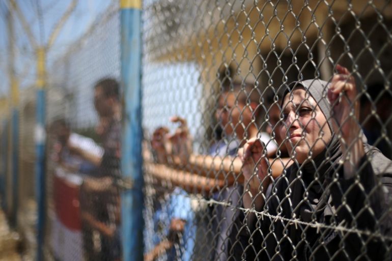 Palestinians gather in front of the gate of Rafah border crossing between Egypt and Gaza during a protest