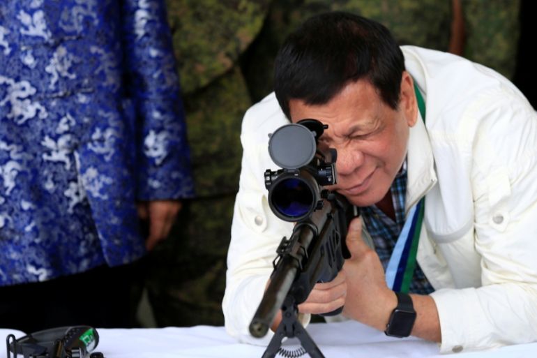 Duterte checks sniper rifle during ceremony at Clark Air Base, near Angeles City