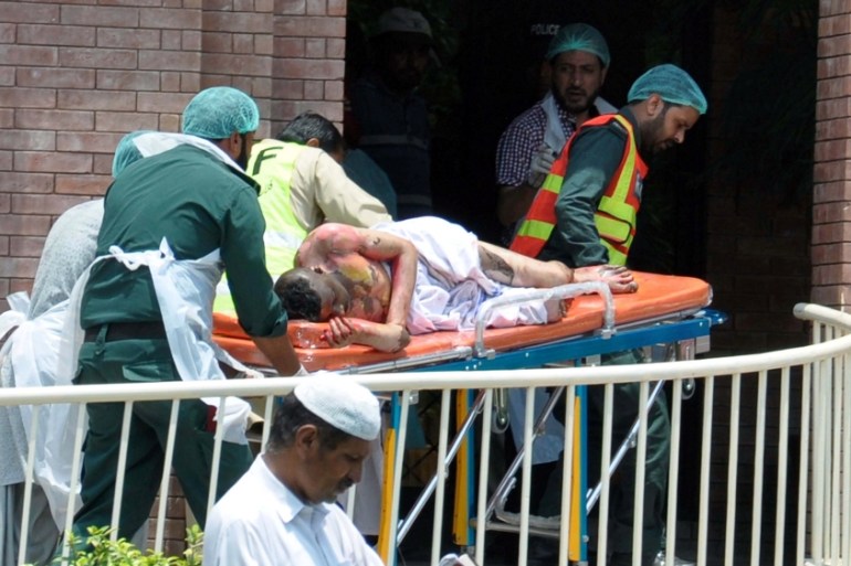 Hospital workers carry in the first victims of an oil tanker explosion in Bahawalpur at Nishtar hospital in Multan