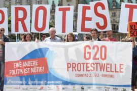 Protestors hold a banner in front of the townhall during a demonstration against the upcoming G20 summit in Hamburg