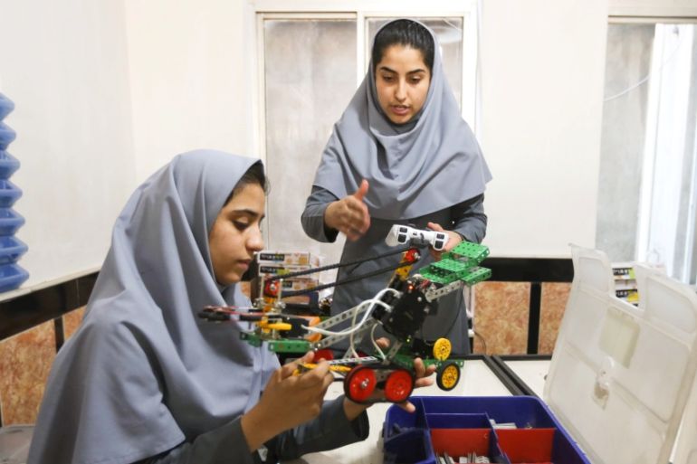 Members of Afghan robotics girls team which was denied entry into the United States for a competition, work on their robots in Herat province