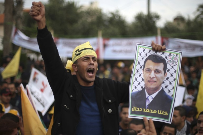A Palestinian supporter of former head of Fatah in Gaza, Mohammed Dahlan, holds a poster during a protest against Palestinian President Mahmoud Abbas in Gaza City