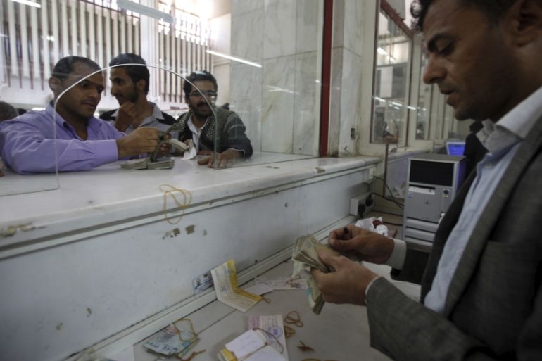 A money exchanger counts Yemeni rials in of the Central Bank of Yemen in Sanaa, Yemen
