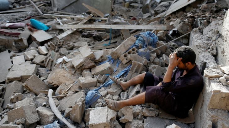 Man sits on the rubble of a house of his relatives, destroyed by a Saudi-led air strike in Sanaa