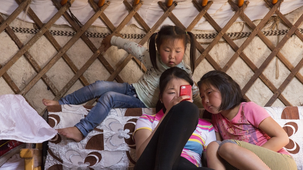 Bujinlkham Damdinsuren, right, inside her family’s ger in Dundgovi Province, Mongolia, with her sisters Namuunbaigal, centre, age 15, and Yanjinlkham, 5, top. Namuunbaigal used to compete in Naadam horse racing when she was younger, and Yanjinlkham hopes to compete next year [Hannah Griffin/Al Jazeera]