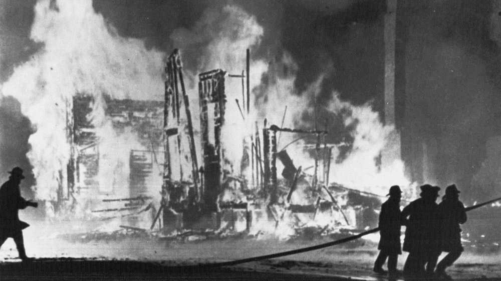 Firefighters try to control blazing buildings after riots in Detroit. Hundreds of fires were reported in the city. Five days of violence would leave 33 blacks and 10 whites dead, and more than 1,400 buildings burned. More than 7,000 people were arrested. [File: The Associated Press]
