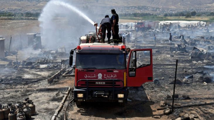 Civil defence members put out fire at a camp for Syrian refugees near the town of Qab Elias