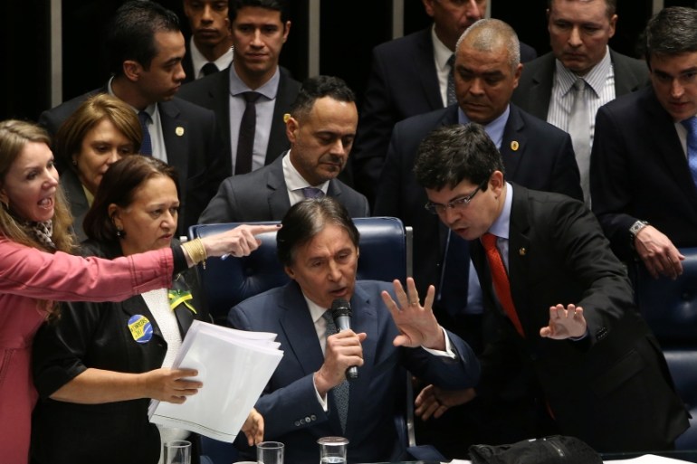 Opposition senators protest as Senate President Oliveira speaks during the session for a vote on labor reform, in Brasilia
